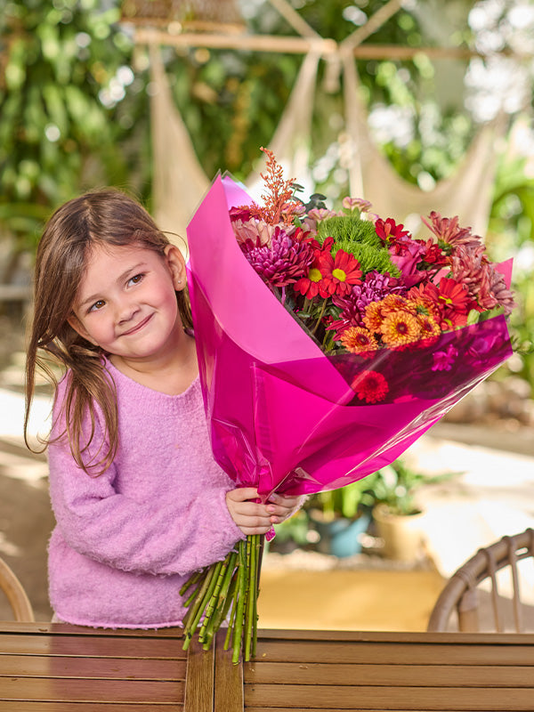 Little girl holding the Candy Prefold Flower Wrapping in Hot Pink