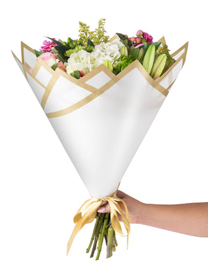 Madonna Wrap in white, wrapped with flowers, with hands holding the bouquet
