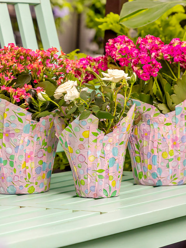 Multicolored pastel pot covers on green bench